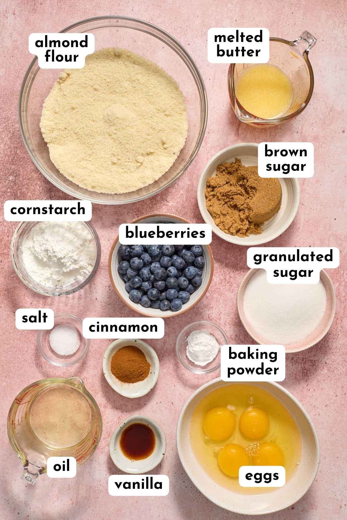 Ingredients to make almond flour blueberry coffee cake muffins arranged individually and labeled.