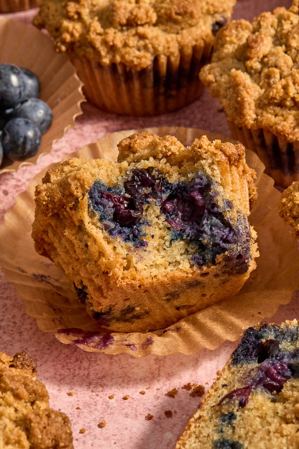 Blueberry muffin on its side with a bite removed.
