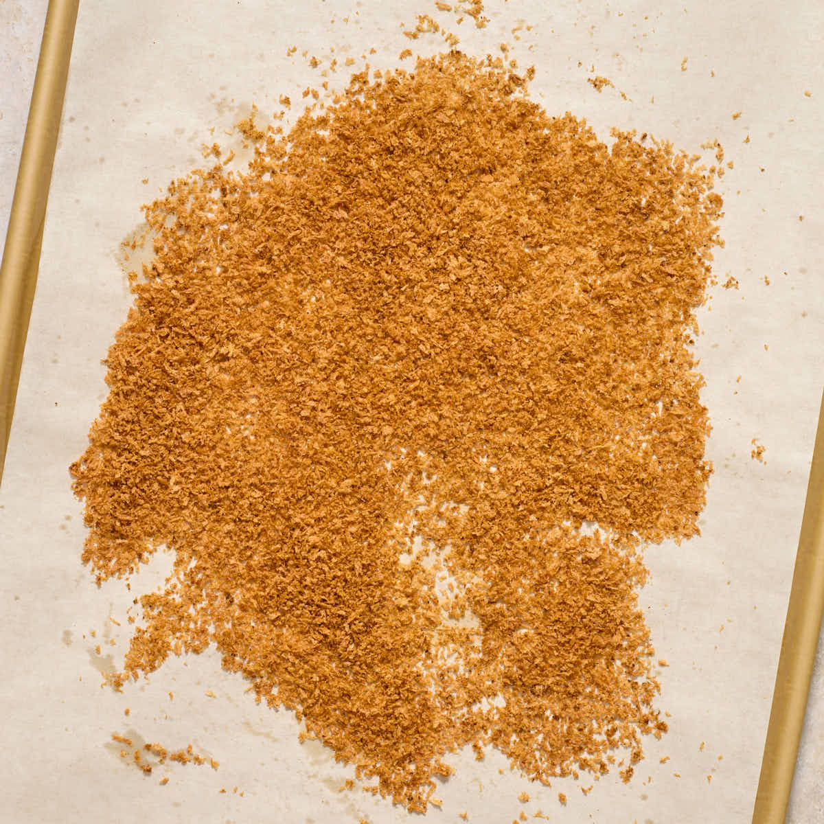 Toasted panko crumbs on a parchment lined baking sheet.