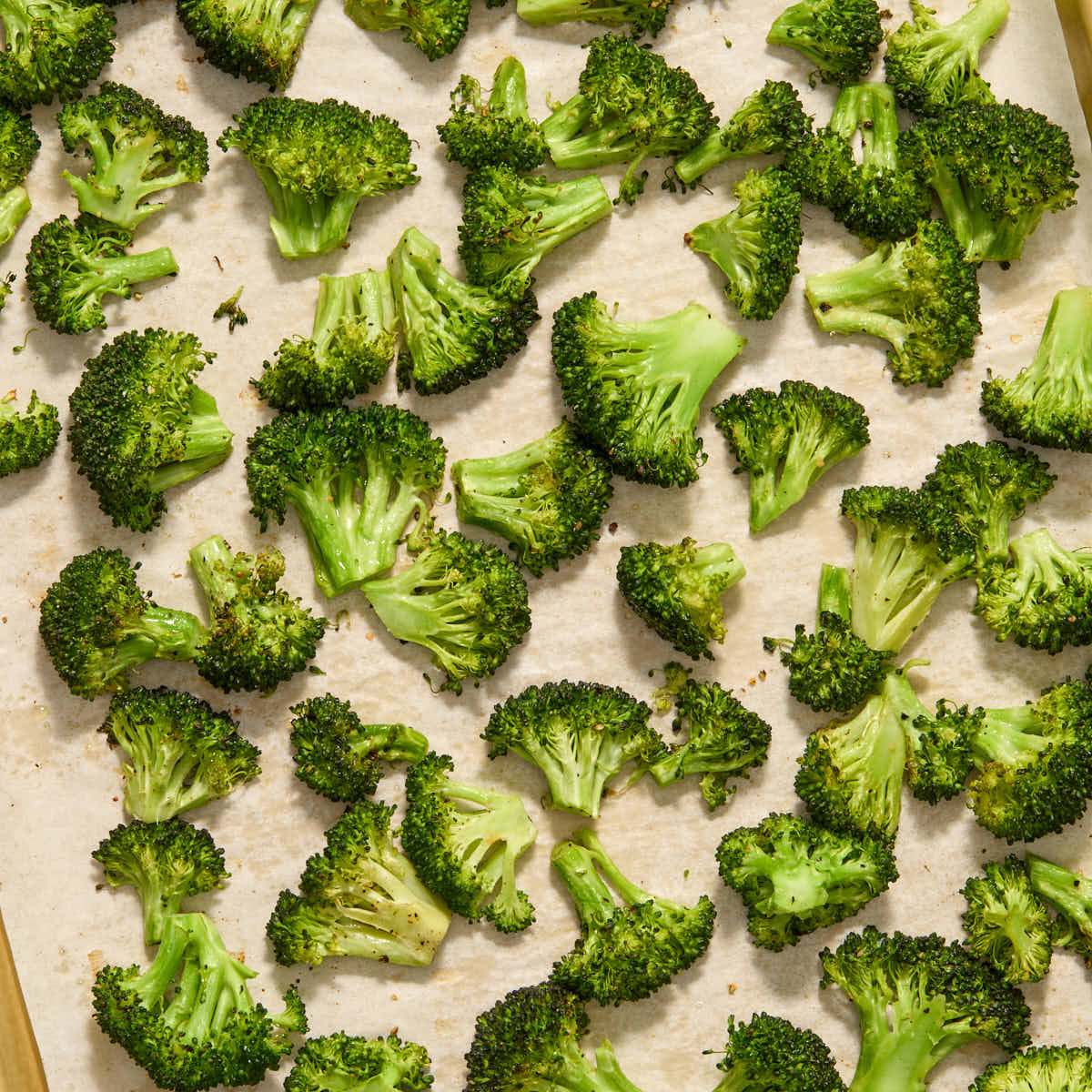 Broccoli florets roasted on a baking sheet.