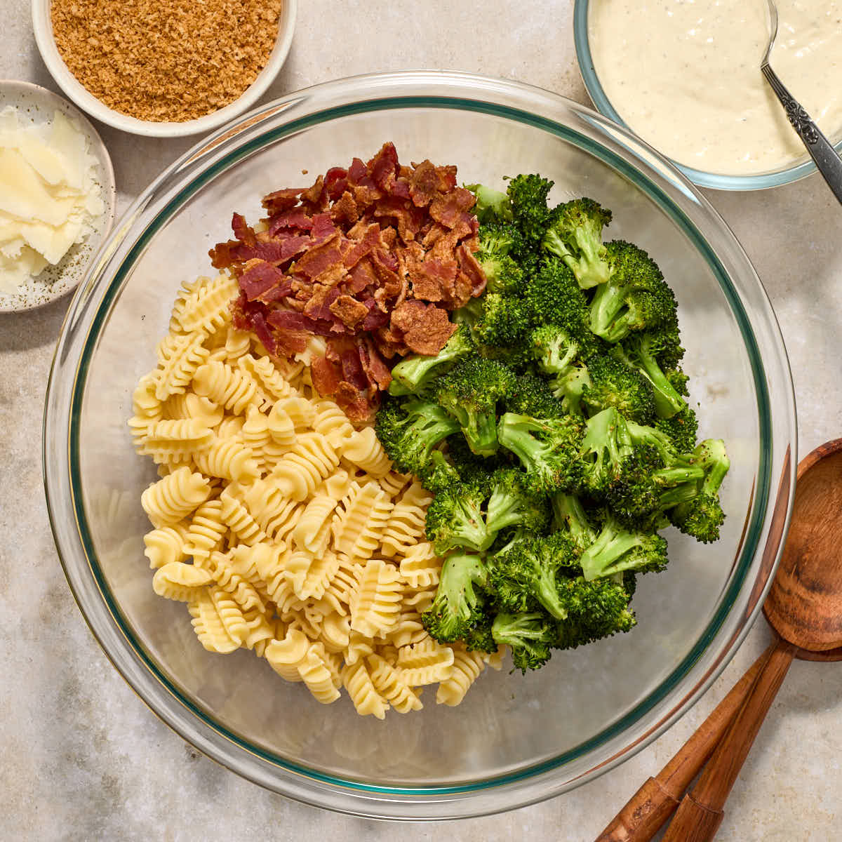 Salad ingredients segmented in a large glass bowl with dressing on the side.