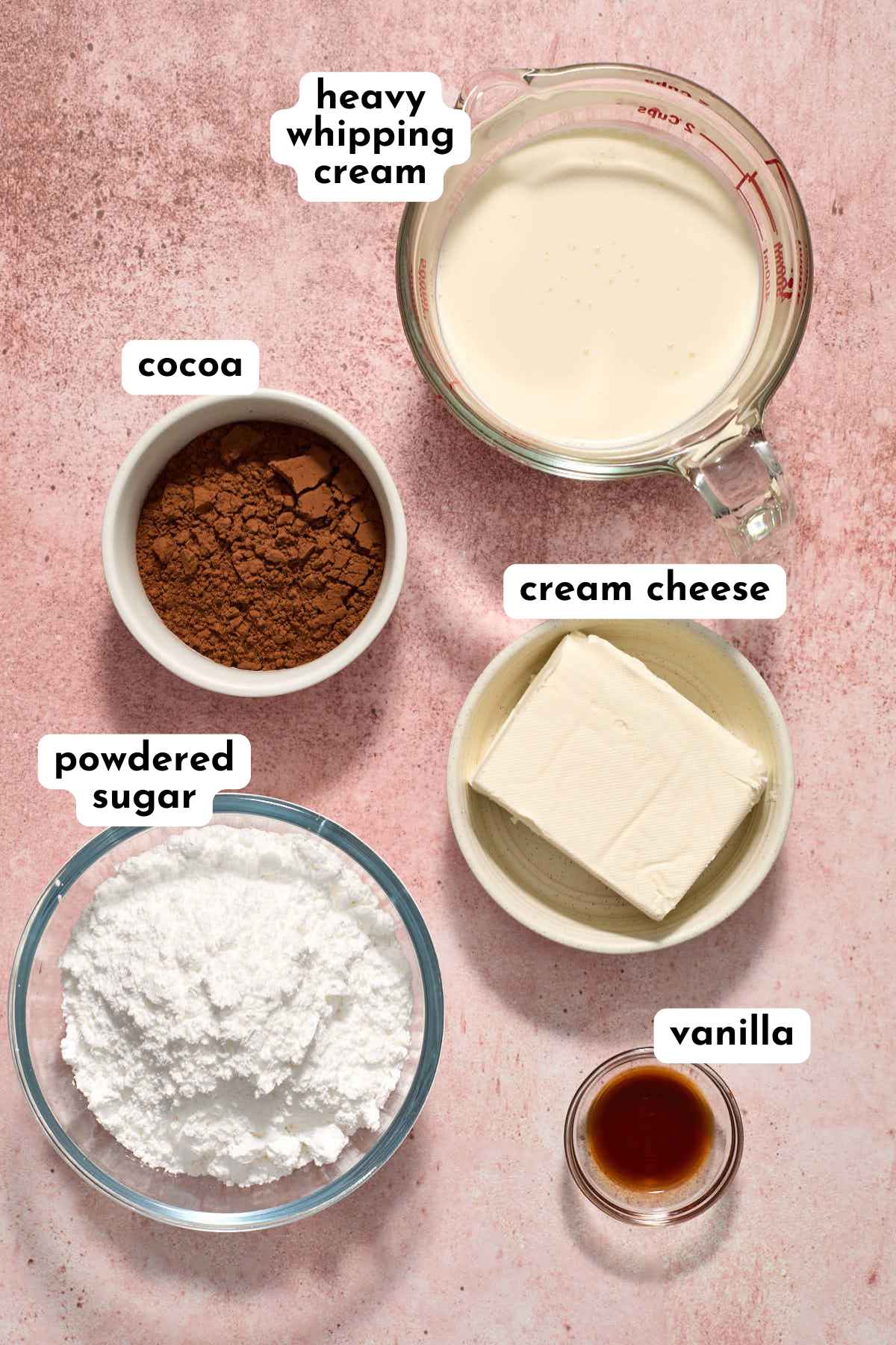 Ingredients for chocolate whipped cream cheese frosting arranged in individual bowls and labeled.