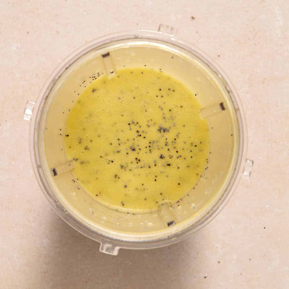 Poppy seeds stirred into the dressing in the blender cup.