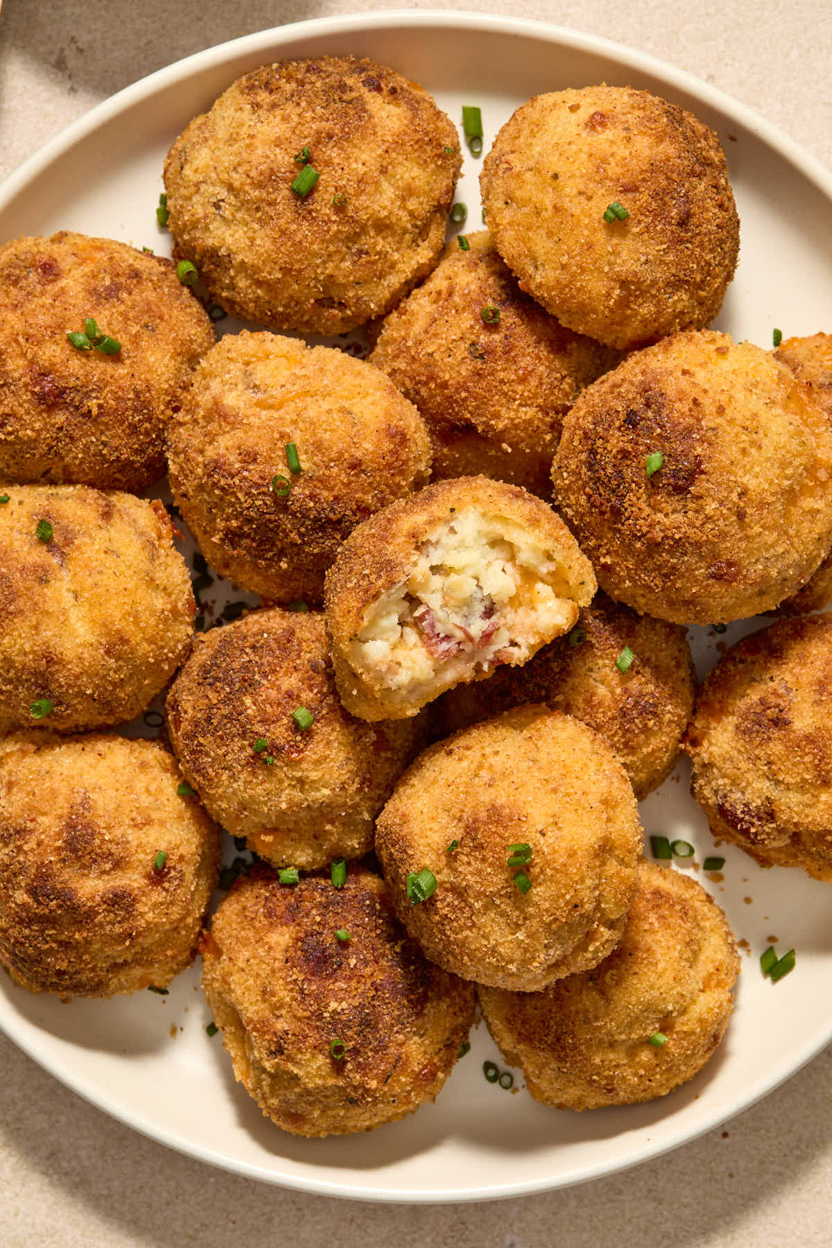A pile of potato balls on a white plate.