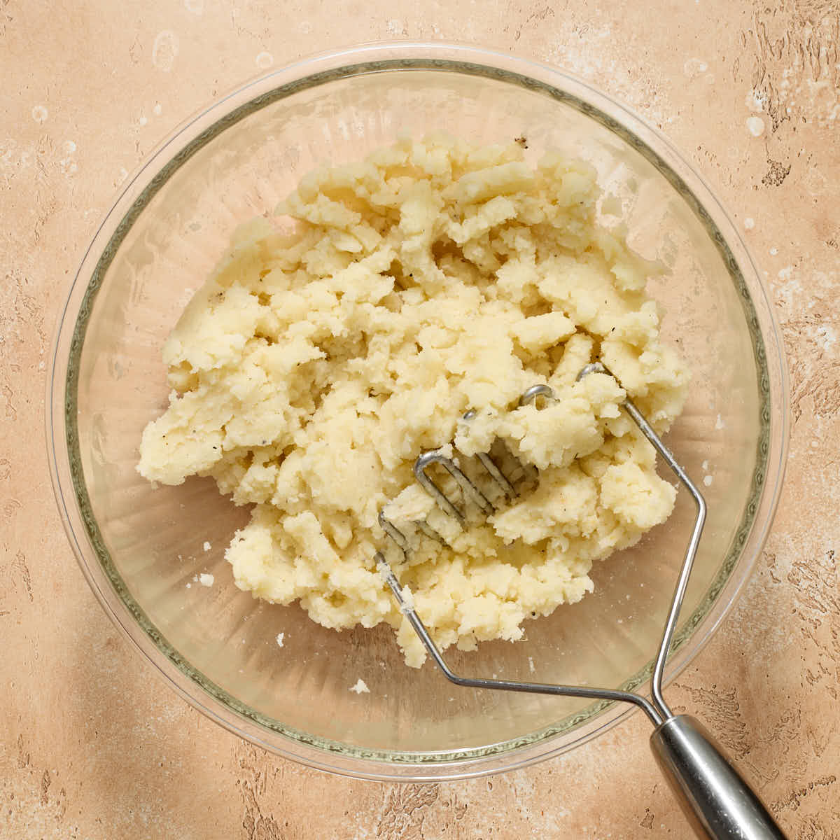 Butter and seasonings mashed into the potatoes with a potato masher.