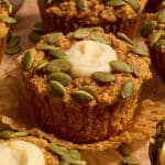 Gluten-free pumpkin cream cheese muffin on a parchment wrapper.