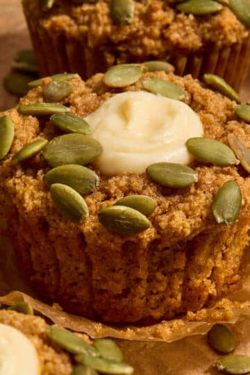 Gluten-free pumpkin cream cheese muffin on a parchment wrapper.
