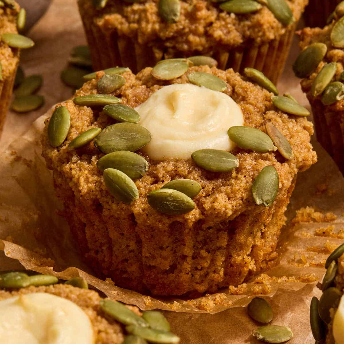Gluten-free pumpkin cream cheese muffin on a parchment wrapper.