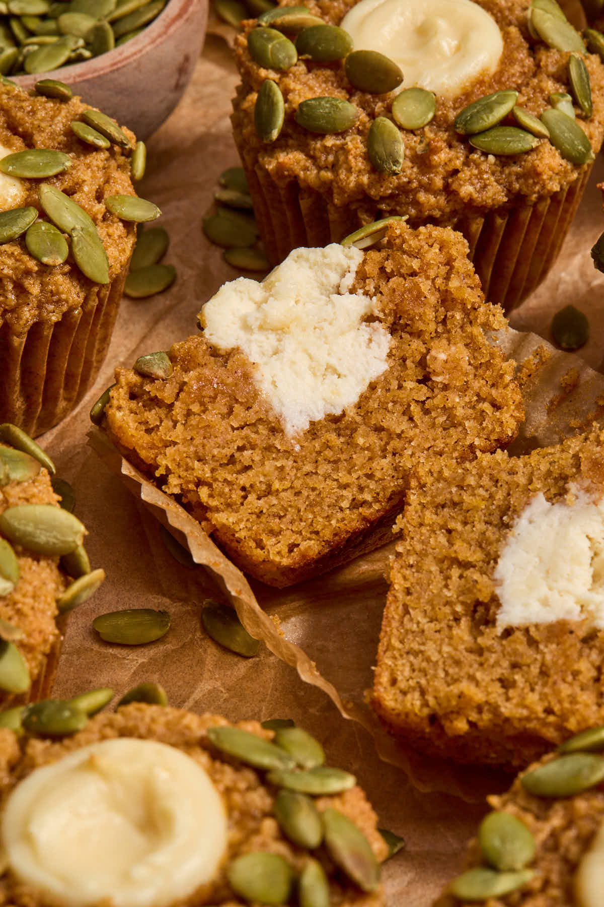 Pumpkin muffin cut in half, showing the cream cheese filling inside.