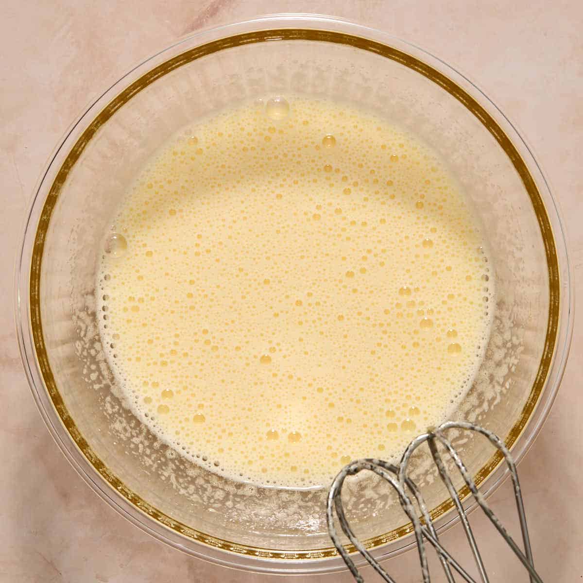 Eggs and sugar beaten together in a glass bowl until pale and just starting to thicken.