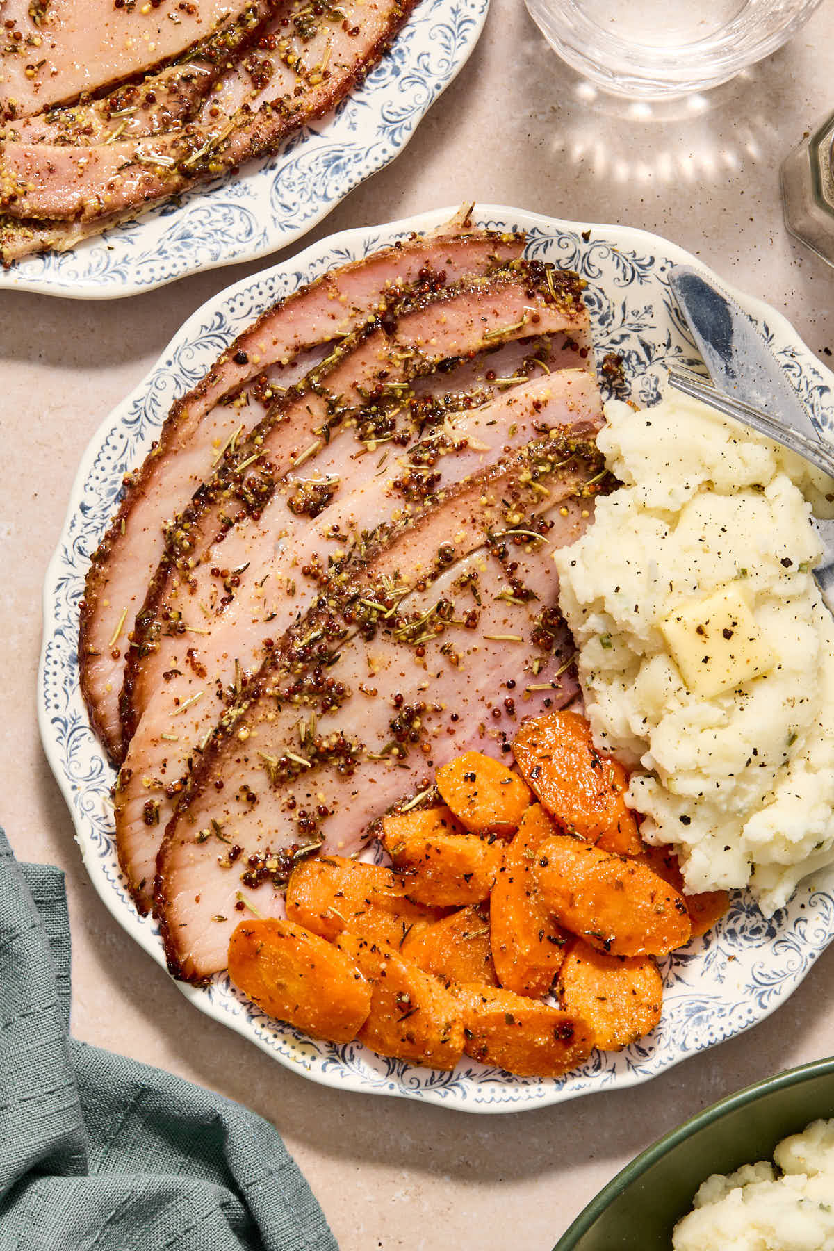 Ham slices served on a plate with mashed potatoes and carrots.