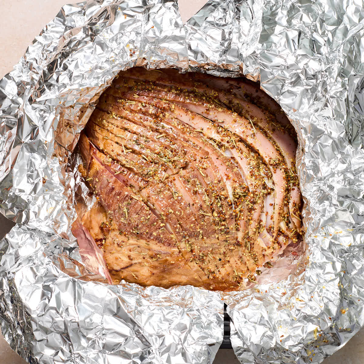 More glaze brushed on the ham in the air fryer basket.