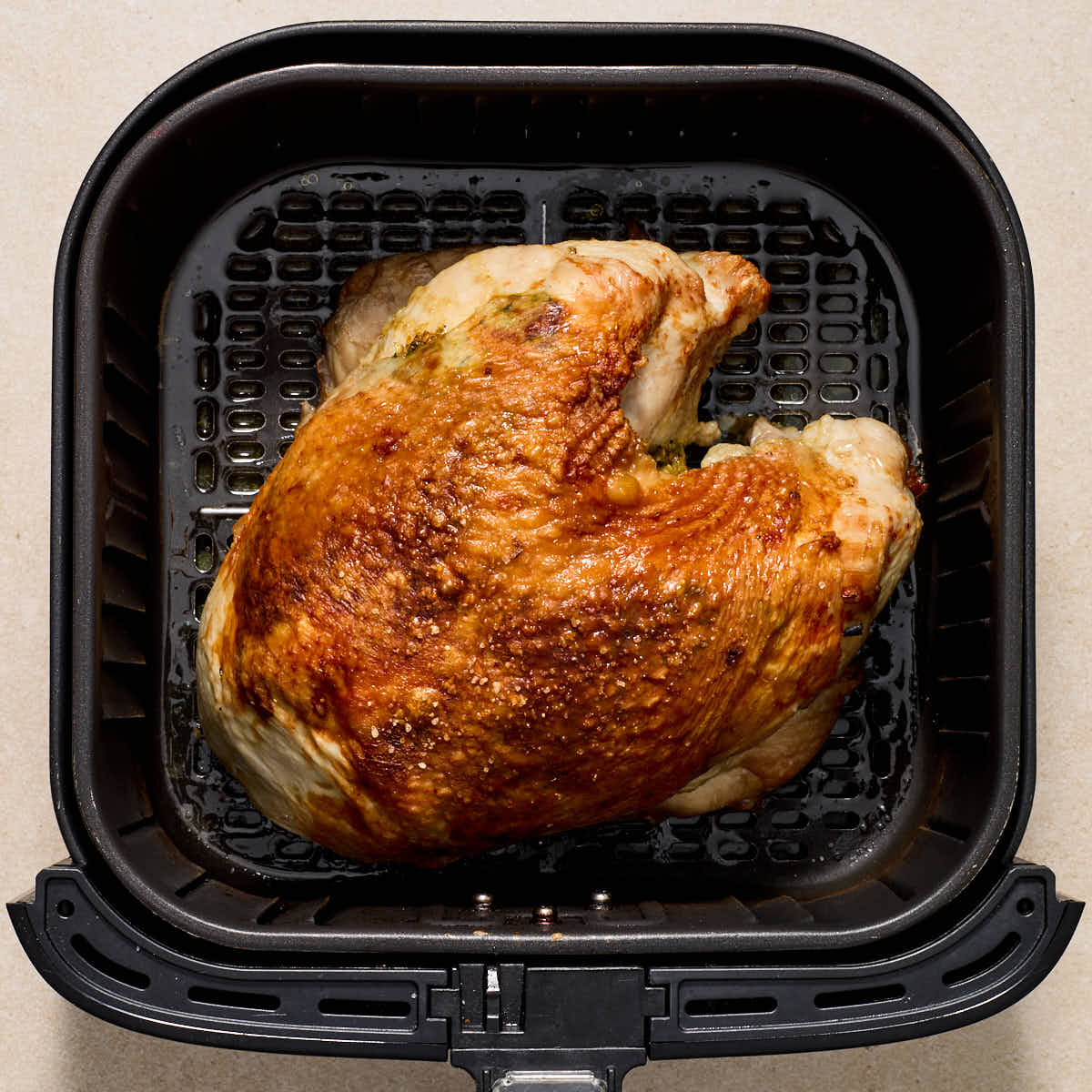 Turkey breast browned in the air fryer basket.