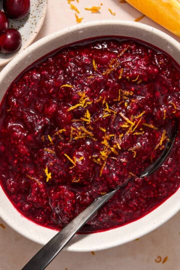 Healthy cranberry sauce with chia seeds and orange served in a white bowl.